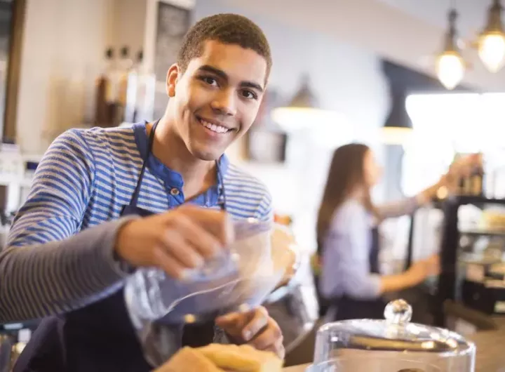 teenage boy working behind counter in a coffee shop