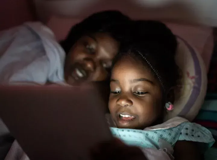 child looks at screen at night 