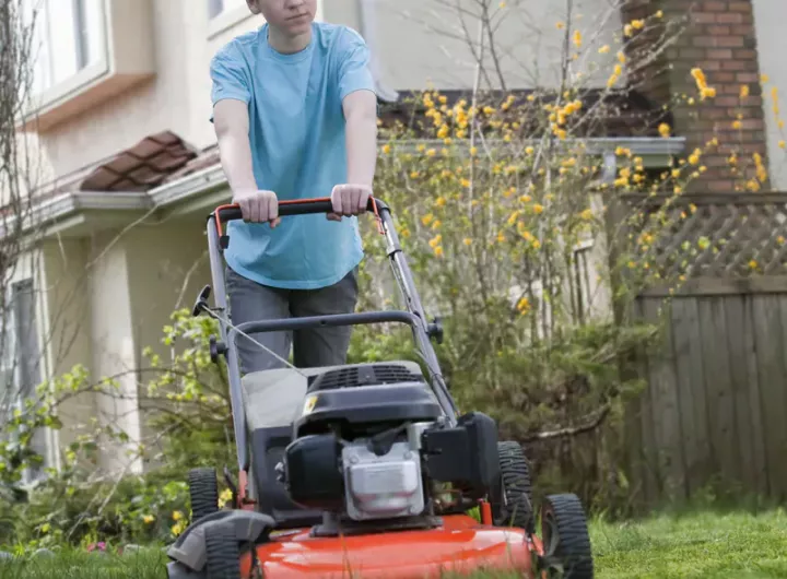 Teenager boy mowing lawn – The benefits of giving your kids chores 